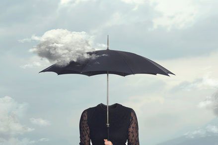 headless woman hiolding umbrella in partly cloudy sky