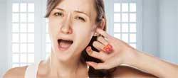 Woman with tinnitus with her finger in her ear