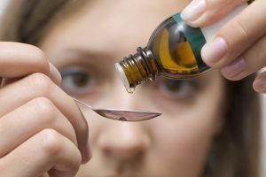 woman dripping homeopathic tincture into spoon
